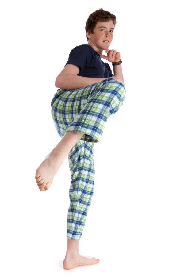 Harry doing a high kick in blue tee shirt and green check brushed cotton lounge pants, both by The Pyjama House